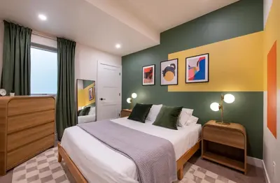 a bedroom with a bed with green and yellow walls at Bright retreat near Tennyson w full kitchen in Denver