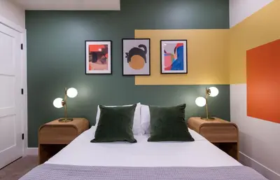 a bedroom with a bed with two lamps on either side at Bright retreat near Tennyson w full kitchen in Denver