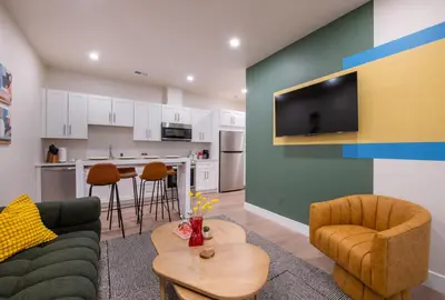 a living room with a couch and a kitchen at Bright retreat near Tennyson w full kitchen in Denver