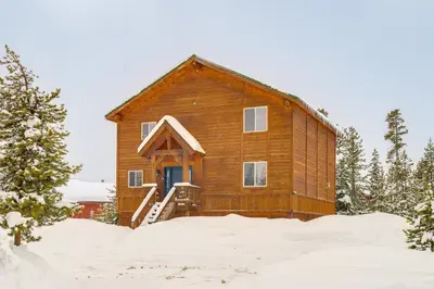 a wooden cabin in the snow with a blue door at 6 Mi to Winter Park Resort Spacious Family Cabin in Fraser