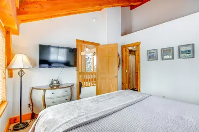 a bedroom with a bed and a dresser and a television at 6 Mi to Winter Park Resort Spacious Family Cabin in Fraser