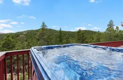 a hot tub on a balcony with a view of a mountain at Golden Oasis in Golden