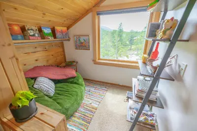 a small room with a green bed in a cabin at Golden Oasis in Golden