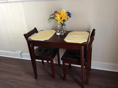 a table with two chairs and a vase of flowers on it at Charming Studio Apartment in the Heart of Golden in Golden