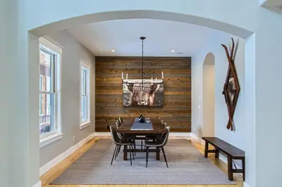 a dining room with a wooden accent wall and a table at Mountain Majesty home in Black Hawk