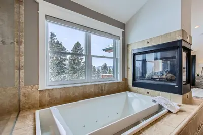 a large bathroom with a tub and a fireplace at Mountain Majesty home in Black Hawk