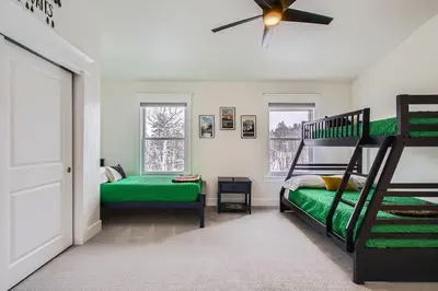 a bedroom with two bunk beds and a ceiling fan at Mountain Majesty home in Black Hawk