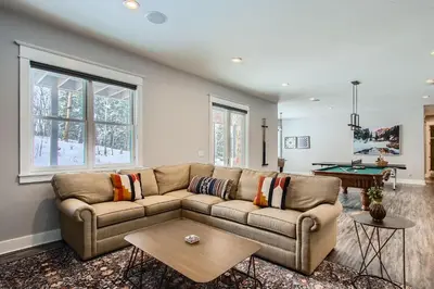 a living room with a couch and a pool table at Mountain Majesty home in Black Hawk