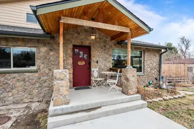 a stone house with a red door and a porch at 180 S Hoyt in Lakewood