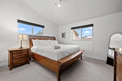 a bedroom with a large bed and two windows at 180 S Hoyt in Lakewood