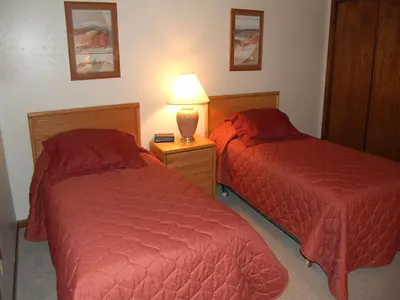 a bedroom with two beds and a lamp on a night stand at Timber Run in Winter Park