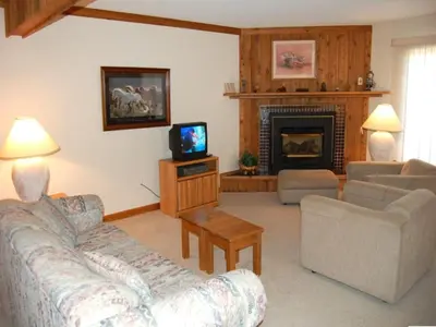 a living room with a couch and a fireplace at Timber Run in Winter Park