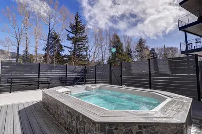 a hot tub in a patio with a fence at River West 515 condo in Silverthorne