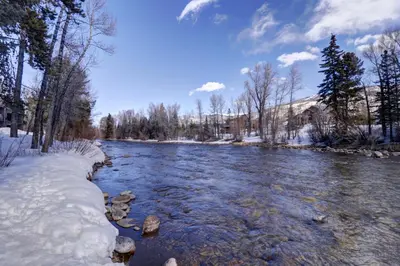 a river with snow on the banks at River West 515 condo in Silverthorne
