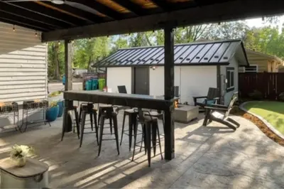 a patio with a bar with stools under a roof at CSU Hideaway with King Bed, Backyard Oasis in Fort Collins