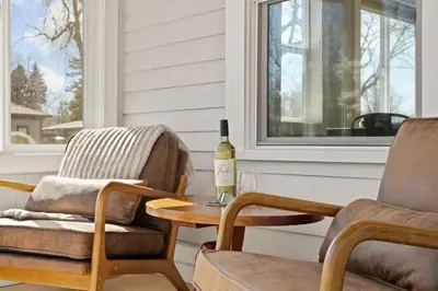 a bottle of wine sitting on a table next to two chairs at CSU Hideaway with King Bed, Backyard Oasis in Fort Collins