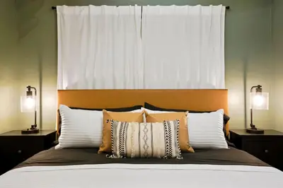 a bedroom with a bed with pillows and a window at BRAND NEW Classic Fire Pit 2 Kings Pet Friendly in Arvada