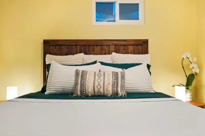a bed with white pillows and a wooden headboard at BRAND NEW Classic Fire Pit 2 Kings Pet Friendly in Arvada