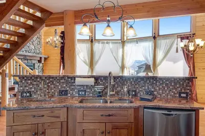 a kitchen with a sink and a large window at Granby Modern Cabin - Hot Tub & Mountain Views in Granby