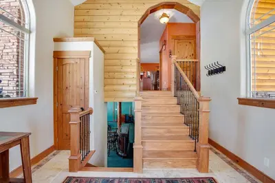 a staircase in a house with wooden walls and ceilings at Granby Modern Cabin - Hot Tub & Mountain Views in Granby