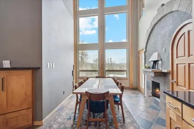 a kitchen with a table and chairs and a fireplace at Luxe & Leisure in Fairways- An Oasis in the Woods in Granby