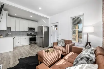 a living room with a couch and a kitchen at Great Remodeled Denver Bungalow in Denver