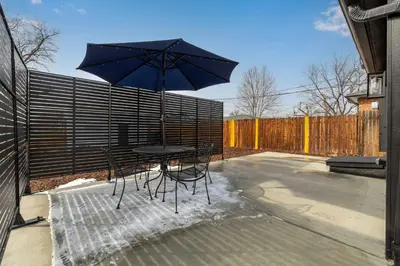 a table and chairs with an umbrella on a patio at Great Remodeled Denver Bungalow in Denver