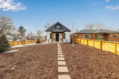 a house with a fence in front of a yard at Great Remodeled Denver Bungalow in Denver