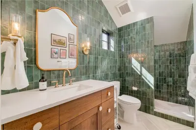 a bathroom with a sink and a toilet and a mirror at Luxe Designer Flat on Sloans Lake with Rooftop Deck in Denver