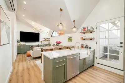 a kitchen with a sink and a living room at Luxe Designer Flat on Sloans Lake with Rooftop Deck in Denver