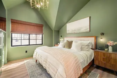 a bedroom with a large bed and a window at Luxe Designer Flat on Sloans Lake with Rooftop Deck in Denver