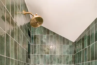 a bathroom with green tiles and a shower at Luxe Designer Flat on Sloans Lake with Rooftop Deck in Denver