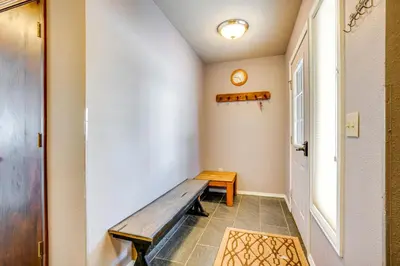 a hallway with a wooden bench next to a door at Home with Mtn Views in Frisco Near 3 Ski Resorts! in Frisco