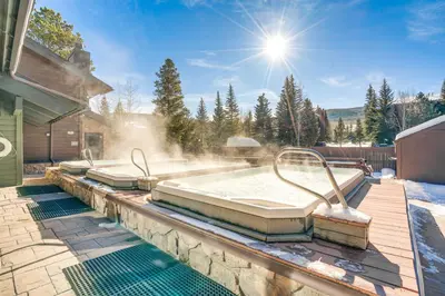 a hot tub on a patio with snow and the sun at Home with Mtn Views in Frisco Near 3 Ski Resorts! in Frisco