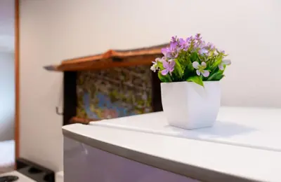 a white vase with purple flowers sitting on a counter at Black Bear Studio in Tranquil Courtyard by Grand Luxe in Grand Lake