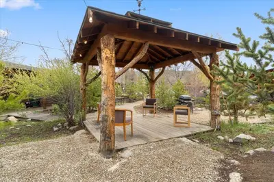 a wooden gazebo with chairs and a grill at Black Bear Studio in Tranquil Courtyard by Grand Luxe in Grand Lake