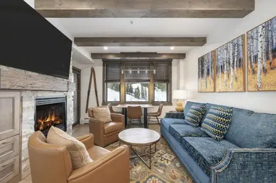 a living room with a blue couch and a fireplace at Select Unit 2509 - Zephyr Mountain Lodge condo in Winter Park