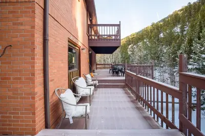 a balcony with chairs and tables on a brick building at Boulder Luxury Getaway 7 acres River & Pond in Boulder