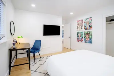 a bedroom with a bed and a desk and a tv at Boulder Luxury Getaway 7 acres River & Pond in Boulder