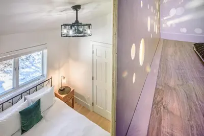 a bedroom with a white bed and a wooden floor at Boulder Luxury Getaway 7 acres River & Pond in Boulder