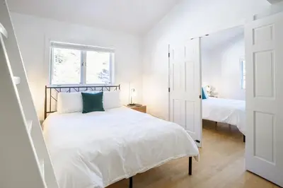 a white bedroom with a bed and a mirror at Boulder Luxury Getaway 7 acres River & Pond in Boulder