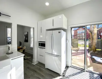 a kitchen with white cabinets and a white refrigerator at Downtown Boulder Luxury in Boulder