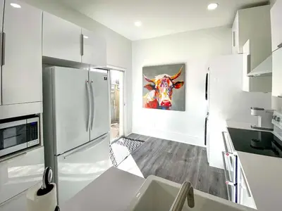 a kitchen with a refrigerator and a painting of a cow at Downtown Boulder Luxury in Boulder