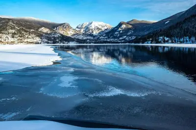 a view of a lake with snow capped mountains at Grand Lake Haven in town, Osprey Studio Cabin in Grand Lake