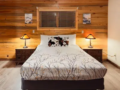 a bedroom with a large bed with two lamps at Grand Lake Haven in town, Osprey Studio Cabin in Grand Lake