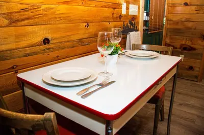 a table with plates and wine glasses on it at Cozy cabin Steps from Lake and Board walk, 5 min RMNP, Moose Lodge Studio in Grand Lake