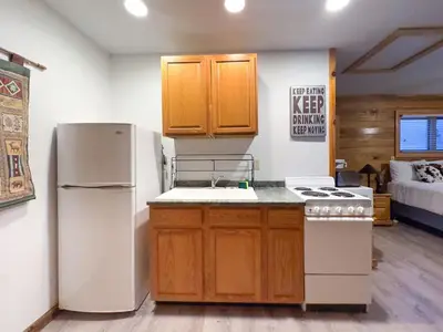 a kitchen with a white refrigerator and a stove at Cozy cabin Steps from Lake and Board walk, 5 min RMNP, Moose Lodge Studio in Grand Lake