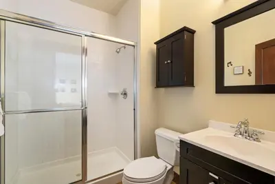 a bathroom with a shower and a toilet and a sink at The Fireside Retreat - 6 BD, Sauna, Home Theater in Greeley