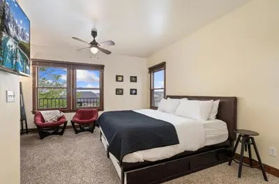 a bedroom with a large bed and two chairs at The Fireside Retreat - 6 BD, Sauna, Home Theater in Greeley
