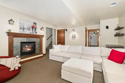 a living room with a white couch and a fireplace at The Fireside Retreat - 6 BD, Sauna, Home Theater in Greeley